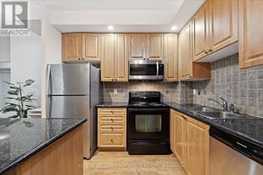 Markham (Unionville) condo for rent - A kitchen with wooden cabinets and a black stove top oven.