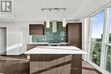 Toronto (Lansing-Westgate) condo for rent - A modern kitchen with a large island and a view of the city.