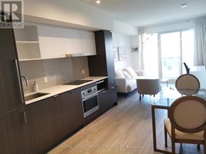 Toronto (Waterfront Communities) condo for rent - A modern kitchen with dark wood cabinets and stainless steel appliances.