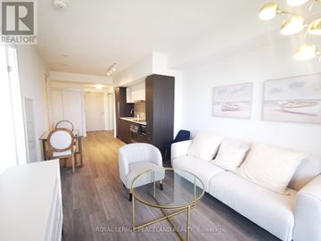 Toronto (Waterfront Communities) condo for rent - A living room with a white couch and a glass coffee table.