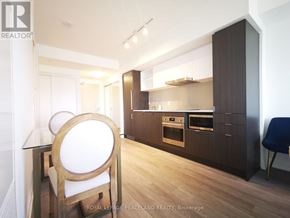 Toronto (Waterfront Communities) condo for rent - A modern kitchen with a dining table and chairs.