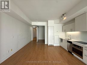 Toronto (Waterfront Communities) condo for rent - A kitchen with white cabinets and a wooden floor.