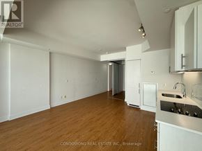 Toronto (Waterfront Communities) condo for rent - A kitchen area with wooden floors and white cabinetry.