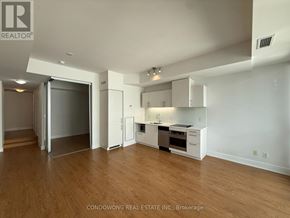 Toronto (Waterfront Communities) condo for rent - A spacious kitchen with white cabinets and a wooden floor.