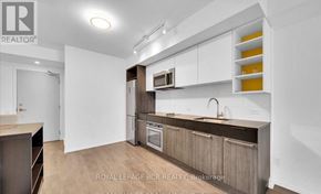 Toronto (Church-Yonge Corridor) condo for rent - A modern kitchen with white cabinets and a wooden island.