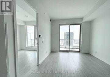 Vaughan (Vaughan Corporate Centre) condo for rent - A spacious, empty room with a sliding glass door leading to a balcony.