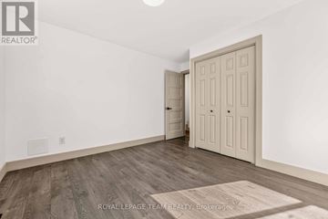 Ottawa triplex for rent - A room with a wooden floor and a white door.