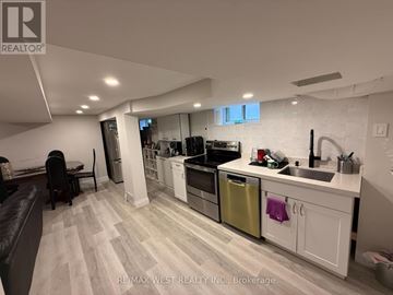 Toronto (Humber Heights) apartment for rent - A modern kitchen with white cabinets and a wooden floor.