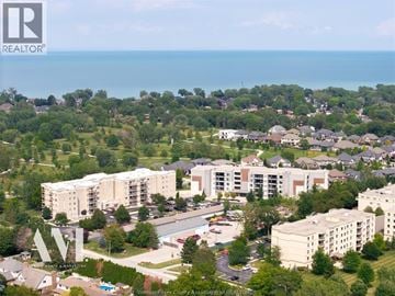Tecumseh condo for rent - A bird's eye view of a residential area with apartment buildings and a swimming pool.