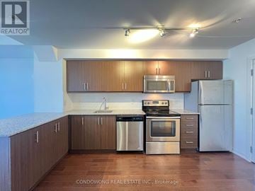 Toronto (Kensington-Chinatown) condo for rent - A kitchen with wooden cabinets and stainless steel appliances.