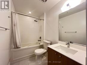 Toronto (Kensington-Chinatown) condo for rent - A white bathroom with a toilet, sink, and bathtub.