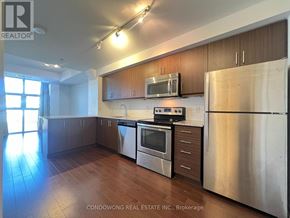 Toronto (Kensington-Chinatown) condo for rent - A kitchen with stainless steel appliances and wooden cabinets.