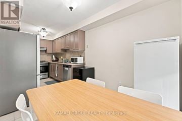 Newmarket (Woodland Hill) townhouse for rent - A kitchen with a table and chairs in front of it.