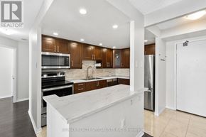 Mississauga (Fairview) condo for rent - A modern kitchen with wooden cabinets and stainless steel appliances.