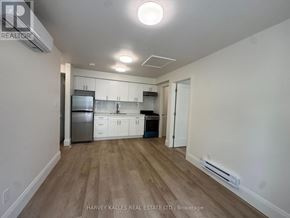 Toronto (Corso Italia-Davenport) apartment for rent - A kitchen with white cabinets and a wooden floor.