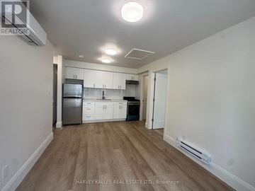 Toronto (Corso Italia-Davenport) apartment for rent - A kitchen with white cabinets and a wooden floor.