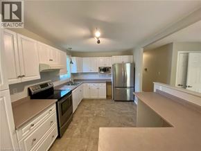 Welland apartment for rent - A kitchen with white cabinets and a black stove top oven.