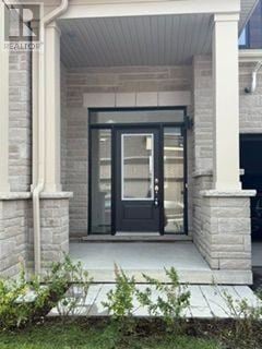 Kawartha Lakes (Lindsay) townhouse for rent - A black door is set in a white frame with a stone pillar on each side.