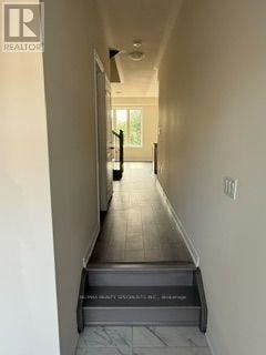 Kawartha Lakes (Lindsay) townhouse for rent - A hallway with a tiled floor and a staircase leading to the second floor.