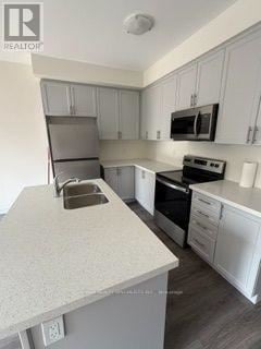 Kawartha Lakes (Lindsay) townhouse for rent - A kitchen with white cabinets and a granite countertop.