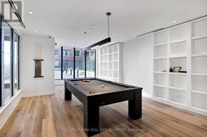Toronto (Thorncliffe Park) townhouse for rent - A billiard table is in the middle of a room with wood floors and white walls.