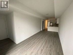 Toronto (Englemount-Lawrence) townhouse for rent - A spacious room with wooden flooring and white walls.