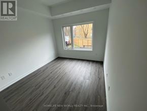 Toronto (Englemount-Lawrence) townhouse for rent - A room with wooden flooring and a window showing an outdoor view.