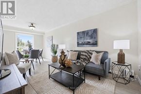 Clarington (Courtice) townhouse for rent - A living room with a grey couch, a coffee table, and a painting on the wall.