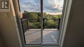 Guelph (Riverside Park) townhouse for rent - A balcony with a black railing and a view of trees and sky.