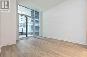 Toronto (Niagara) condo for rent - A room with a view of a cityscape through a glass door.