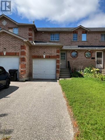 Barrie (Holly) townhouse for rent - A house with a driveway and a car parked in front.