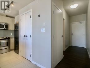 Burnaby apartment for rent - A kitchen with white cabinets and appliances, a white door, and a white wall.
