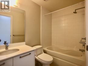 Burnaby apartment for rent - A white bathroom with a toilet, sink, and bathtub.