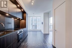 Toronto (Waterfront Communities) condo for rent - A modern kitchen with dark wood cabinets and stainless steel appliances.