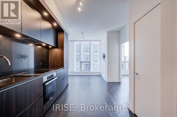 Toronto (Waterfront Communities) condo for rent - A modern kitchen with dark wood cabinets and stainless steel appliances.