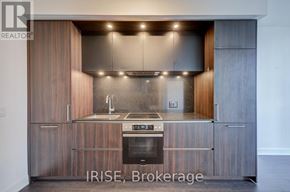 Toronto (Waterfront Communities) condo for rent - A modern kitchen with wooden cabinets and stainless steel appliances.