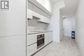 Toronto (Thorncliffe Park) condo for rent - A white kitchen with a stove top oven and a white fridge.