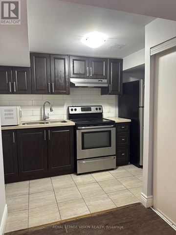 Toronto (Woburn) apartment for rent - A kitchen with dark wood cabinets and stainless steel appliances.