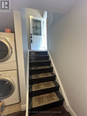 Toronto (Woburn) apartment for rent - A white washing machine sits next to a staircase.