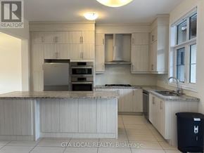 Vaughan (Patterson) townhouse for rent - A kitchen with white cabinets and a granite countertop.