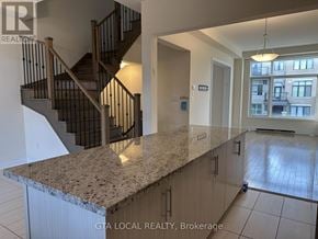 Vaughan (Patterson) townhouse for rent - A spacious kitchen with granite countertops and a staircase in the background.