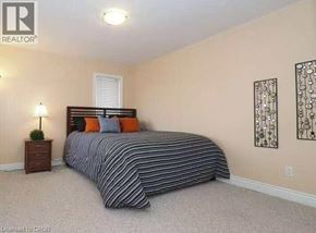 Waterloo apartment for rent - A bedroom with a bed, nightstand, and two wall art pieces.