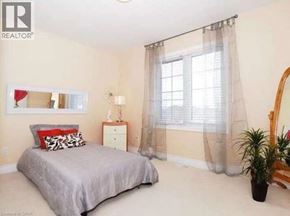 Waterloo apartment for rent - A bedroom with a bed, nightstand, and a plant.