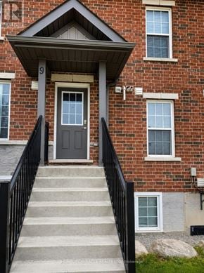 Barrie (Georgian Drive) townhouse for rent - A brick house with a black door and a black railing.