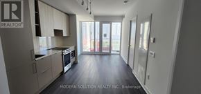 Mississauga (City Centre) condo for rent - A modern kitchen with wooden floors and white walls.