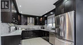 Brampton (Northwood Park) apartment for rent - A modern kitchen with black cabinets and stainless steel appliances.