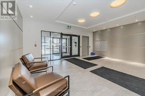 Kitchener condo for rent - A waiting area with brown leather chairs and a black and white rug.