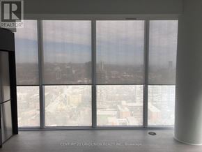 Toronto (Moss Park) condo for rent - A view of a cityscape through a window in a room with a pillar.