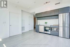 Toronto (Moss Park) condo for rent - A modern kitchen with stainless steel appliances and white cabinets.