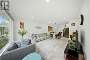 Mississauga (Applewood) apartment for rent - A living room with a grey couch, a white sofa, a rug, and a TV.